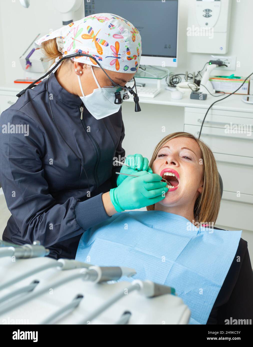 Joven Blond paciente femenino con boca abierta examinando la inspección dental en la oficina del dentista. Foto de stock