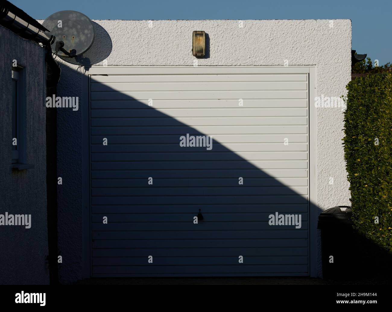 Puerta blanca del garaje con la mitad a la sombra y la mitad a la luz del  sol Fotografía de stock - Alamy