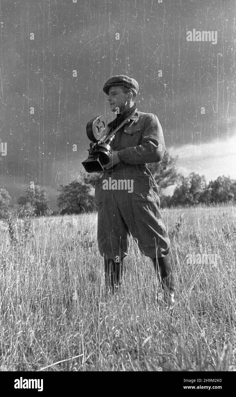 Warszawa, 1948-09. Brygada Traktorowa Zwi¹zku M³odzie¿y Polskiej pomaga³a w pracach polowych w maj¹tku Pañstwowych Nieruchomoœci Ziemskich (PNZ) w Warszawa. NZ. Operador Polskiej Kroniki Filmowej Sergiusz Sprudin, który dokumentuje przebieg PPRPOPONOWYCH. msa PAP Dok³adny dzieñ wydarzenia nieustalony. Warszawa, 1948 de septiembre. Una Brigada de Tractor de la Unión Juvenil Polaca que ayuda en el trabajo de campo en el estado de la Propiedad desembarcada del Estado (Panstwowe Nieruchomosci Ziemskie -PNZ) en Varsovia. Foto: El camarógrafo polaco Sergiusz Sprudin filma trabajo de campo. msa PAP Foto de stock