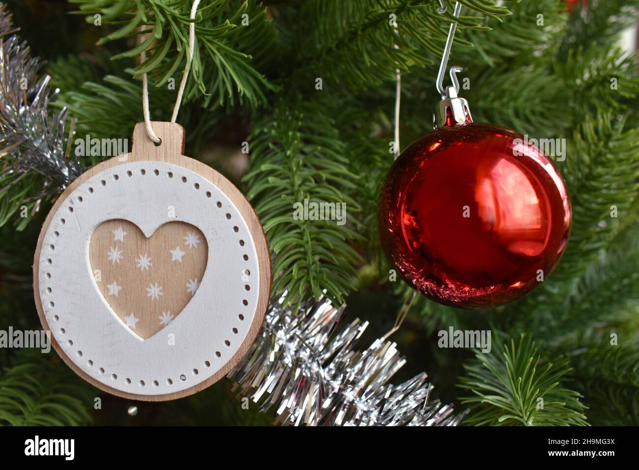 Corazón y la bola roja dentro del árbol de Navidad. Foto de stock
