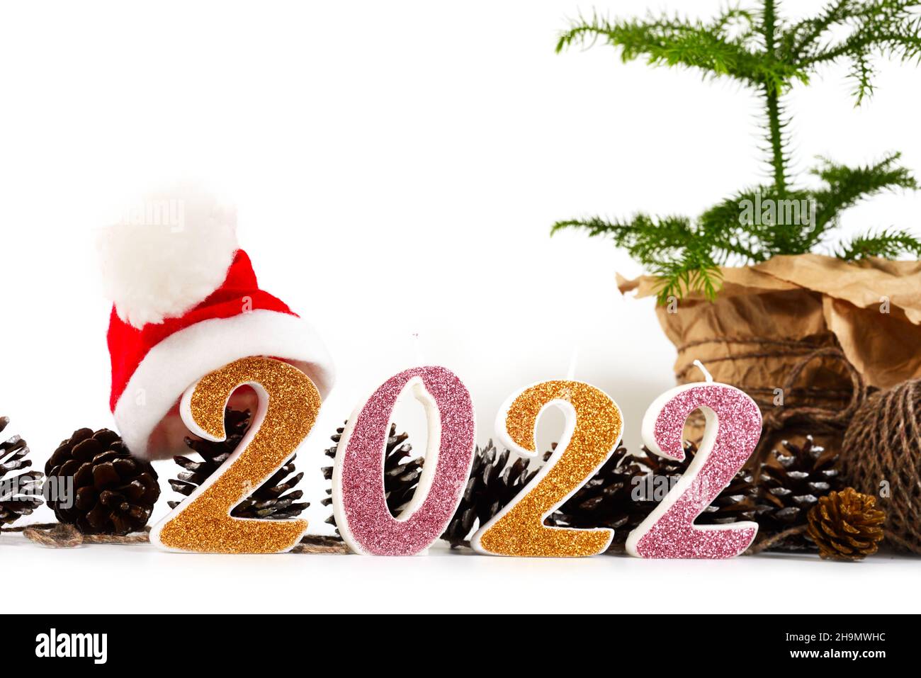 Concepto de Navidad, pino verde en maceta, números 2022 y sombrero de Santa. Espacio vacío para texto. Foto de stock
