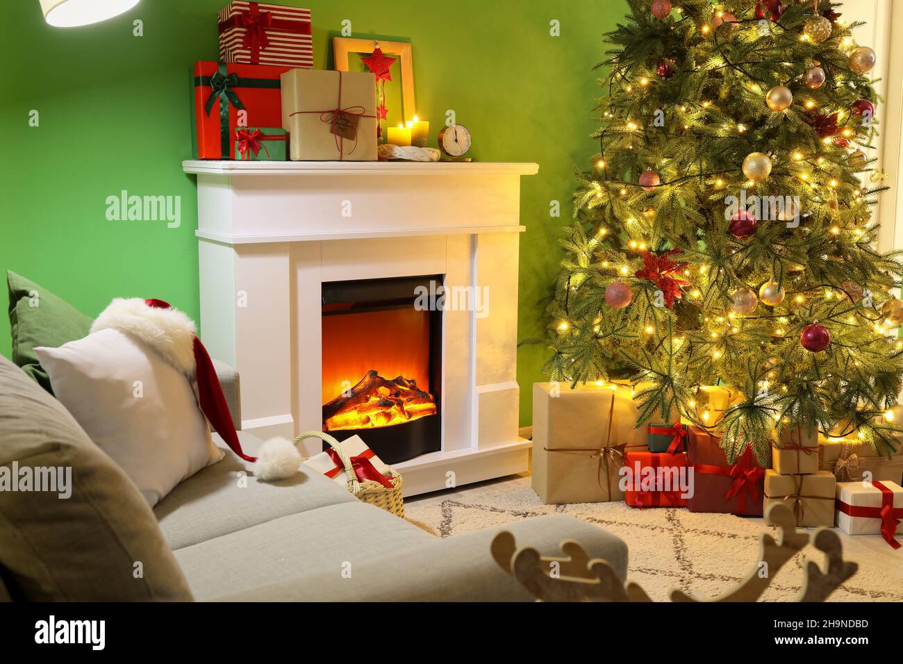 Interior de la sala de estar con chimenea, cajas de regalo y un gran árbol  de Navidad Fotografía de stock - Alamy