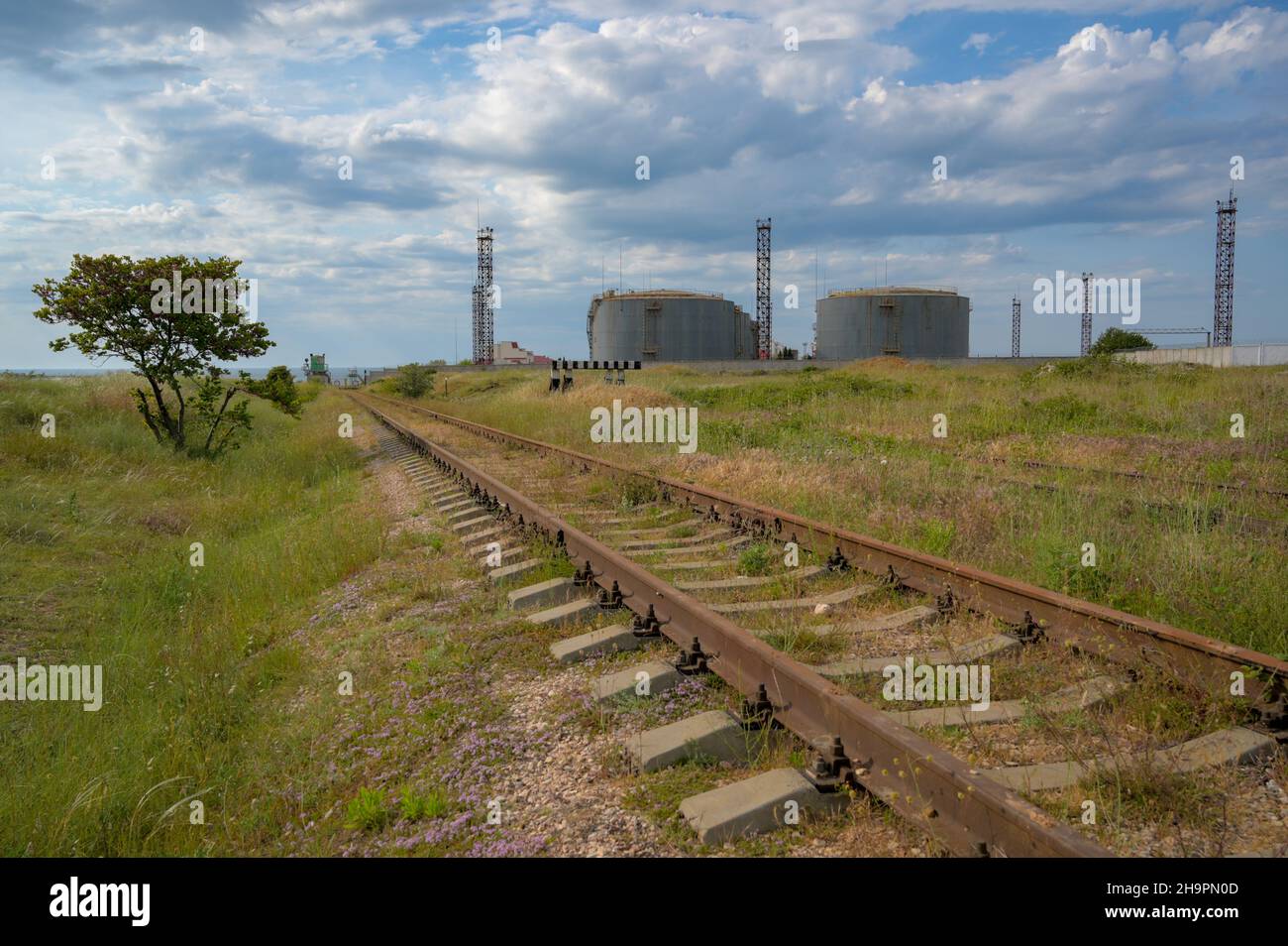 antiguo tren oxidado y tanques de petróleo cisterna en el fondo Foto de stock