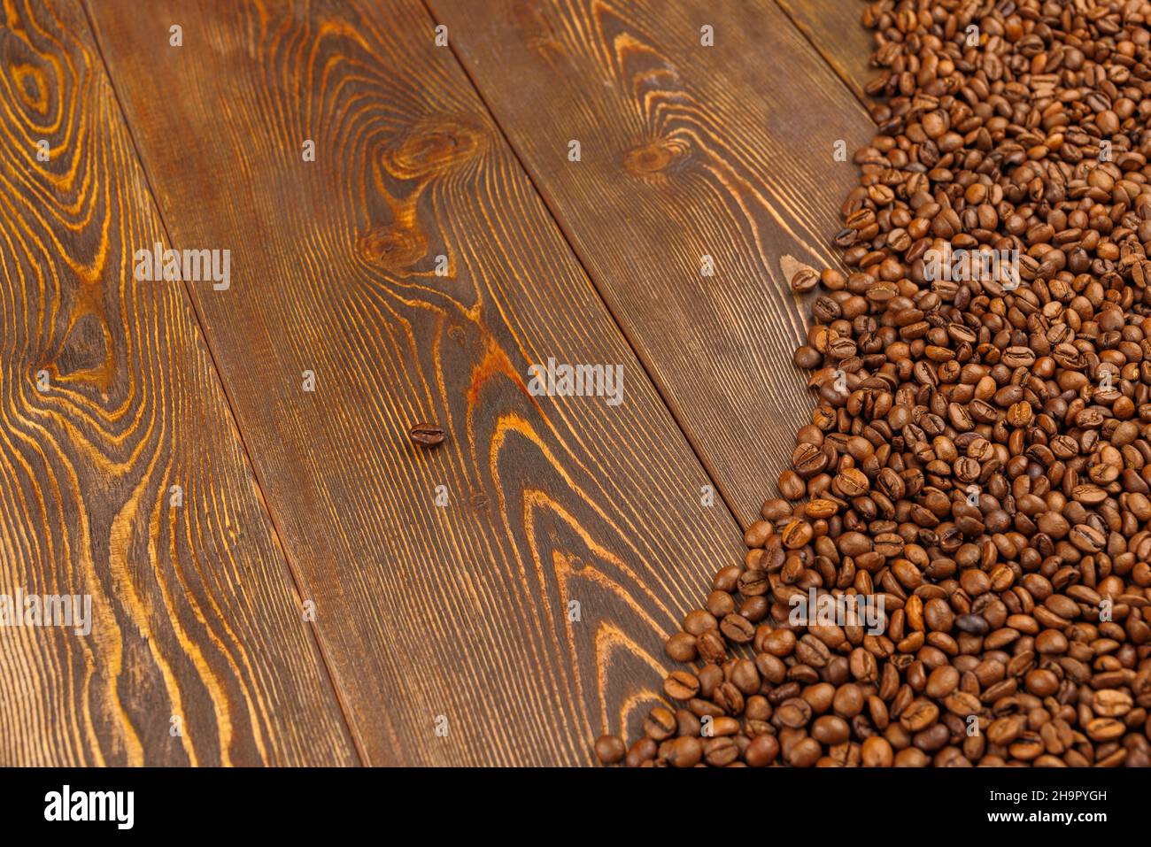 granos de café asados sobre la superficie de la mesa de madera marrón Foto de stock