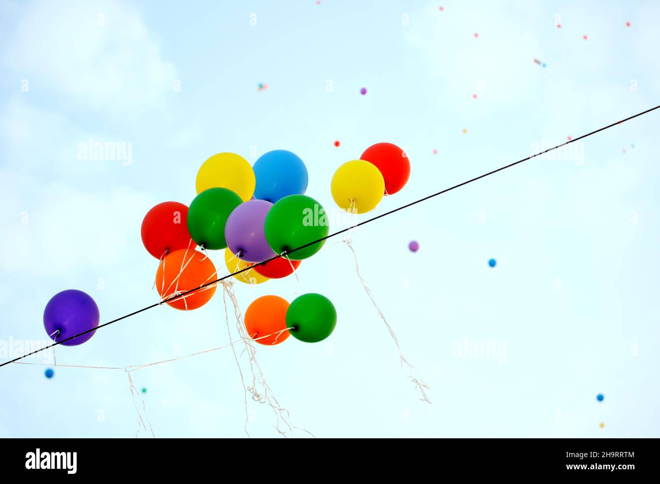 El festival ha terminado, globos multicolores atrapar en el cable eléctrico Foto de stock