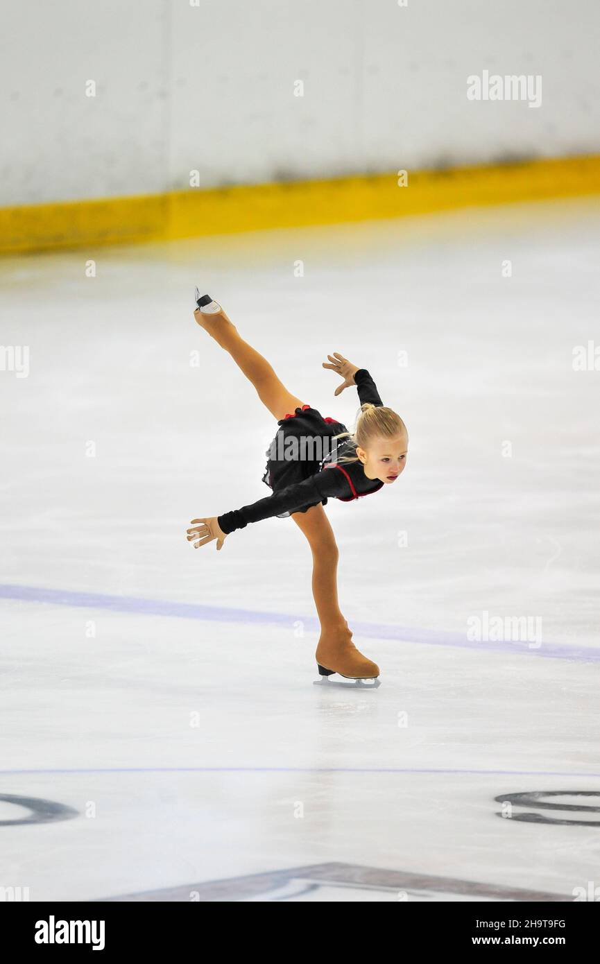 Niña pequeña figura patinador en hielo interior Foto de stock