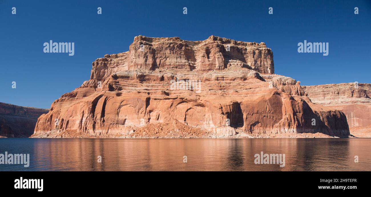 Área Nacional de Recreación de Glen Canyon, Utah, Estados Unidos. majestuosa colina de arenisca roja reflejada en las tranquilas aguas del Lago Powell. Foto de stock