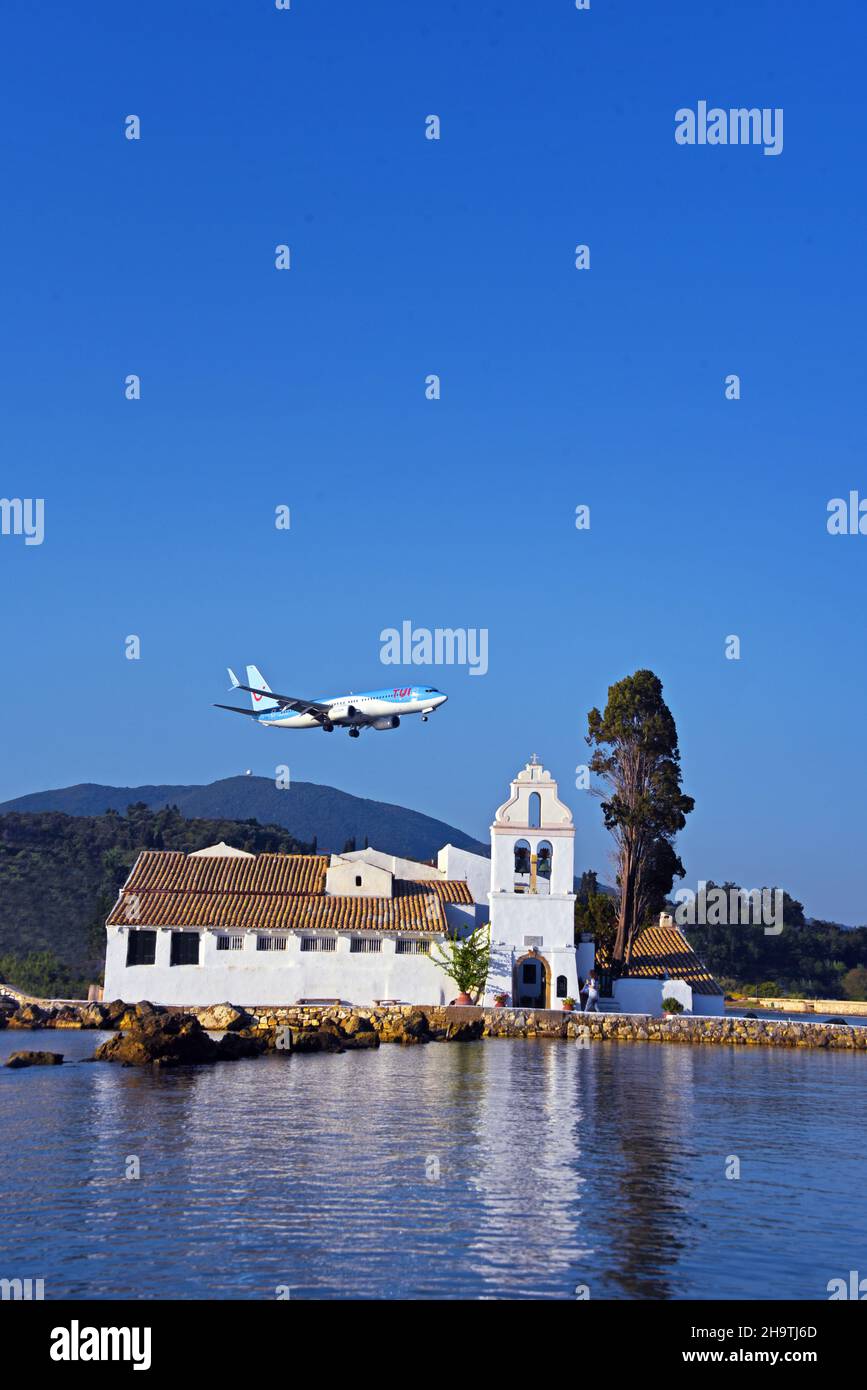 Un avión de aproximación para aterrizar sobre el monasterio de Vlacherna en el centro de una bahía, Grecia, Islas Jónicas, Corfú, Kerkira Foto de stock