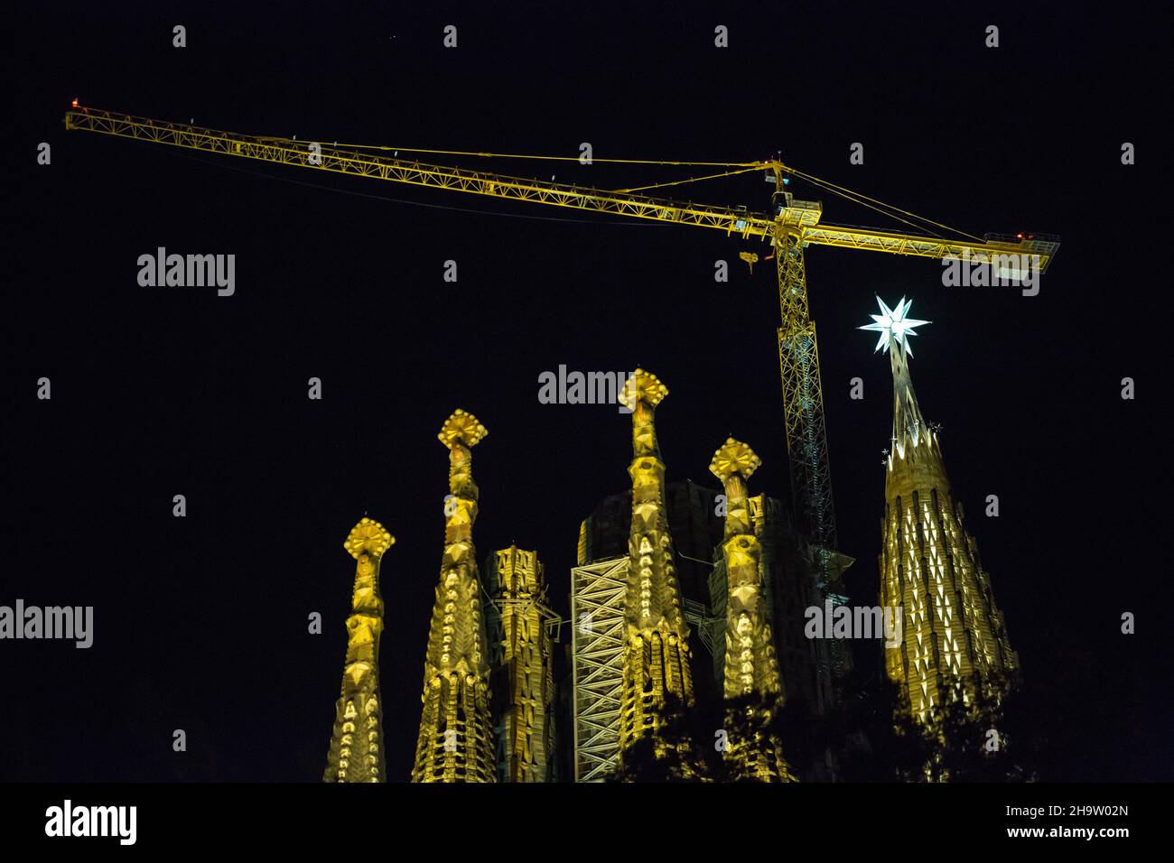 Barcelona, Cataluña, España. 8th de Dic de 2021. La estrella de doce puntas se ilumina desde la cima de una de las torres de la Basílica de la Sagrada Familia en Barcelona. La estrella recién instalada en la torre de la Virgen María de la Basílica de la Sagrada Familia se ha iluminado que el 8 de diciembre, fiesta de la Inmaculada Concepción, Por primera vez desde su instalación el 29 de noviembre. La Basílica de la Sagrada Familia es una obra maestra de la catedral de Antoni Gaudí. Es una famosa Basílica que tardó más de cien años en construirse, pero todavía está inacabada. (Imagen de crédito: © Thiago Prud Foto de stock