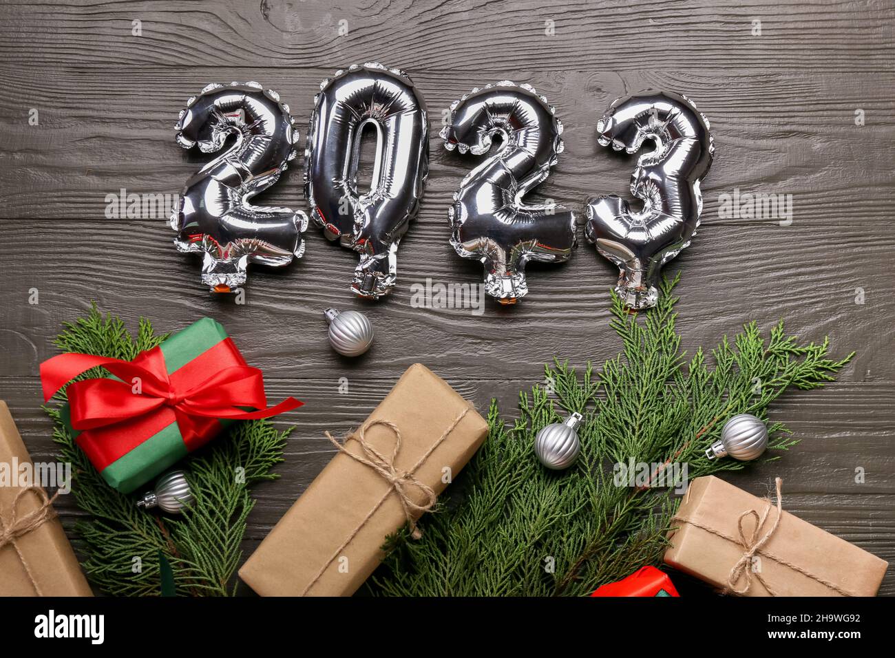 Globos de plata en forma de figura 2023, cajas de regalo y decoración de  Navidad sobre fondo de madera oscura Fotografía de stock - Alamy