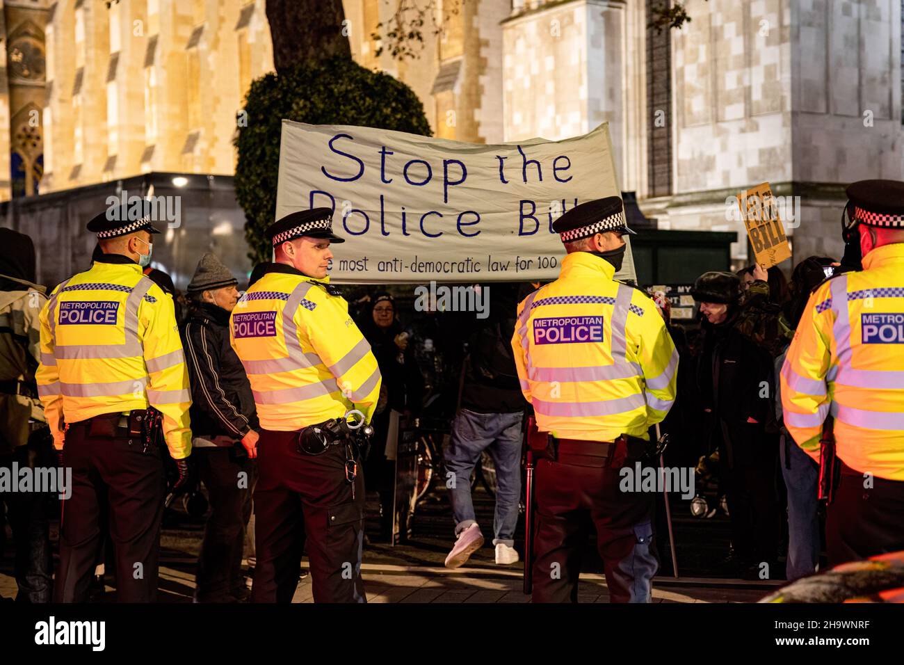 Londres, Reino Unido. 08th de Dic de 2021. El manifestante sostiene una bandera de 'Stop the Police Bill' delante de los policías durante la manifestación. Los manifestantes se reunieron en la Plaza del Parlamento para protestar contra el proyecto de ley sobre la policía, el delito, las sentencias y los tribunales, que los críticos dicen que harán ilegales muchas formas de protesta. Crédito: SOPA Images Limited/Alamy Live News Foto de stock