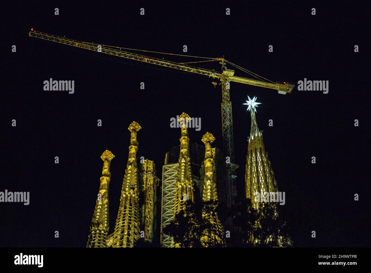 La estrella de doce puntas se ilumina desde la cima de una de las torres de la Basílica de la Sagrada Familia. La estrella recién instalada en la torre de la Virgen María de la Basílica de la Sagrada Familia se ha iluminado el 8 de diciembre, durante la fiesta de la Inmaculada Concepción, Por primera vez desde su instalación el 29 de noviembre. La Basílica de la Sagrada Familia es una obra maestra de la catedral de Antoni Gaudí. Es una famosa Basílica que tardó más de cien años en ser construida, pero todavía está inacabada. Foto de stock