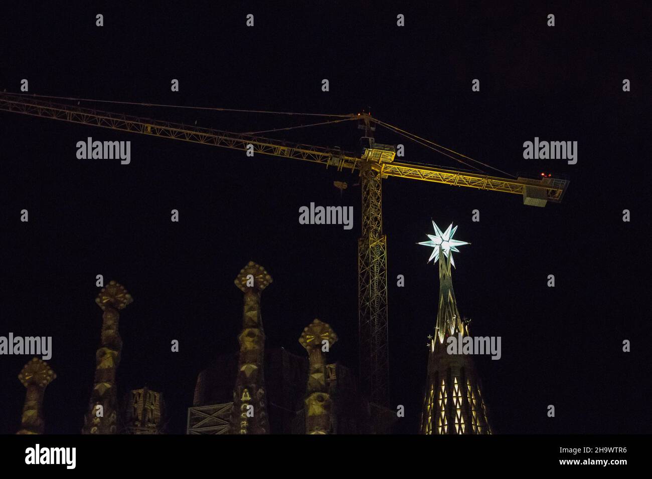 La estrella de doce puntas se ilumina desde la cima de una de las torres de la Basílica de la Sagrada Familia. La estrella recién instalada en la torre de la Virgen María de la Basílica de la Sagrada Familia se ha iluminado el 8 de diciembre, durante la fiesta de la Inmaculada Concepción, Por primera vez desde su instalación el 29 de noviembre. La Basílica de la Sagrada Familia es una obra maestra de la catedral de Antoni Gaudí. Es una famosa Basílica que tardó más de cien años en ser construida, pero todavía está inacabada. Foto de stock