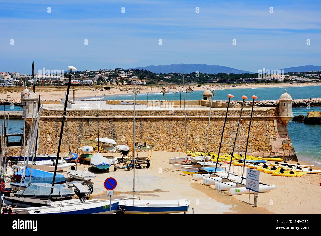 La vista de la elevada fortaleza Ponta da Bandeira con barcos en primer plano y vistas a la playa, Lagos, Algarve, Portugal, Europa. Foto de stock
