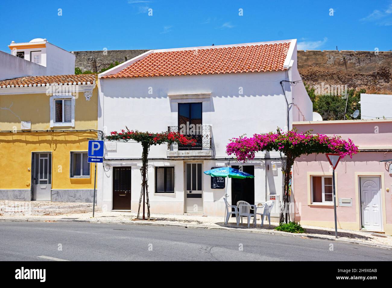 Cafeterías a lo largo de una calle de la ciudad con bonitas bougainvillea, Castro Marim, Algarve, Portugal, Europa. Foto de stock