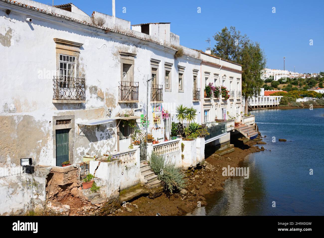 Waterfront adosados a lo largo de la orilla del río Gilao con escaleras que conducen al agua, Tavira, Algarve, Portugal, Europa. Foto de stock