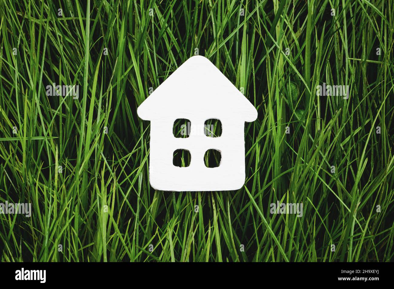 Casa de papel blanco sobre hierba verde, vida sostenible y vivienda ecológica Foto de stock