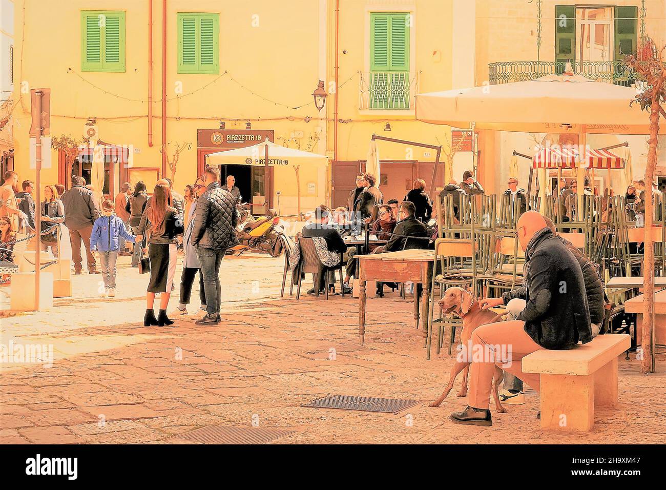 Monopoli,Italia,0310/2019: Multitud de personas un domingo soleado, en la plaza de la ciudad de Monopoli, Apulia, hizo relación social. Foto de stock