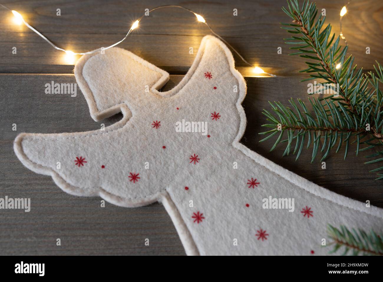 un lindo ángel de navidad de fieltro con luces de guirnalda y rama de  abeto. Fondo del tiempo de Navidad Fotografía de stock - Alamy