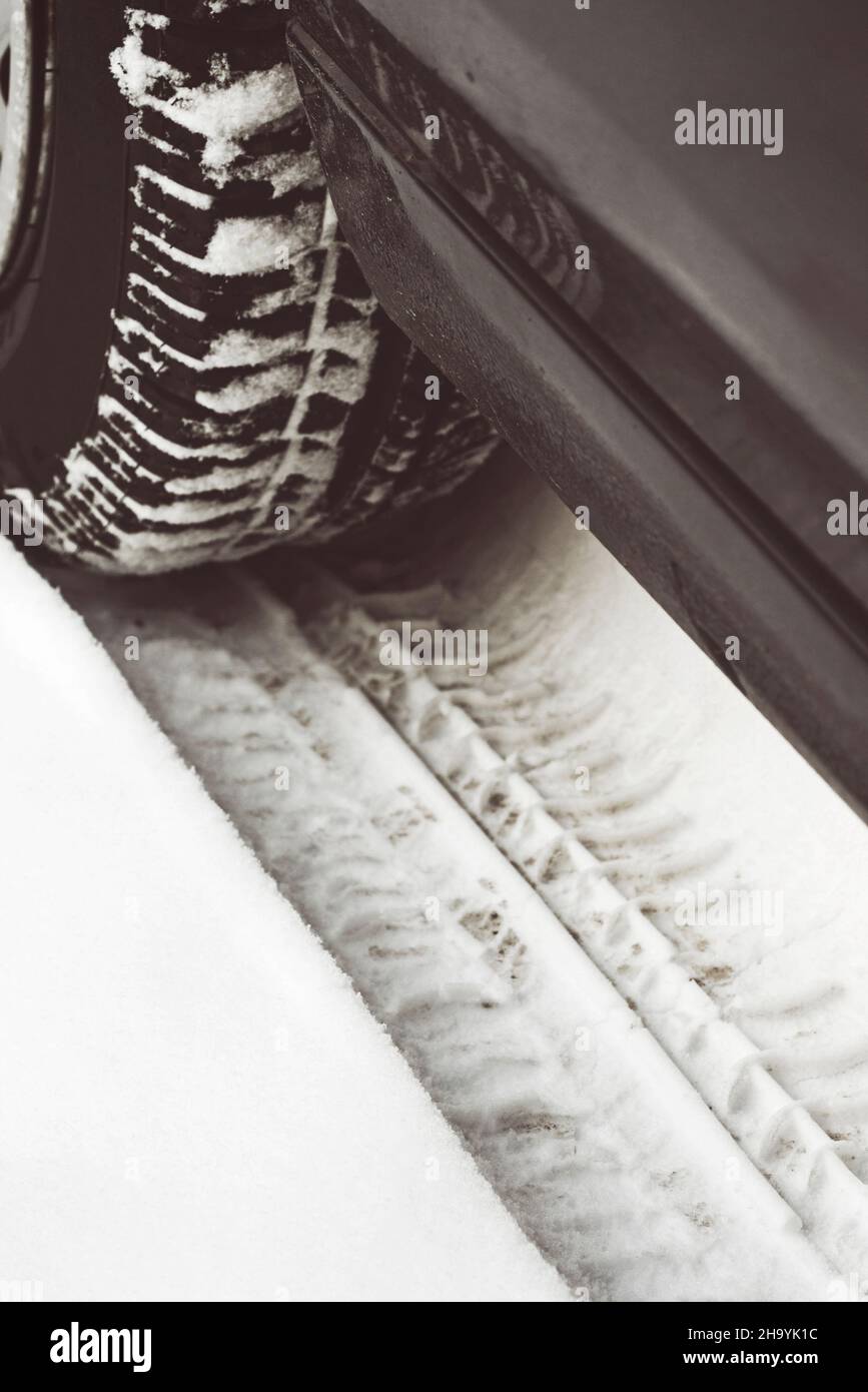 Las huellas de neumáticos de coche en la nieve Foto de stock