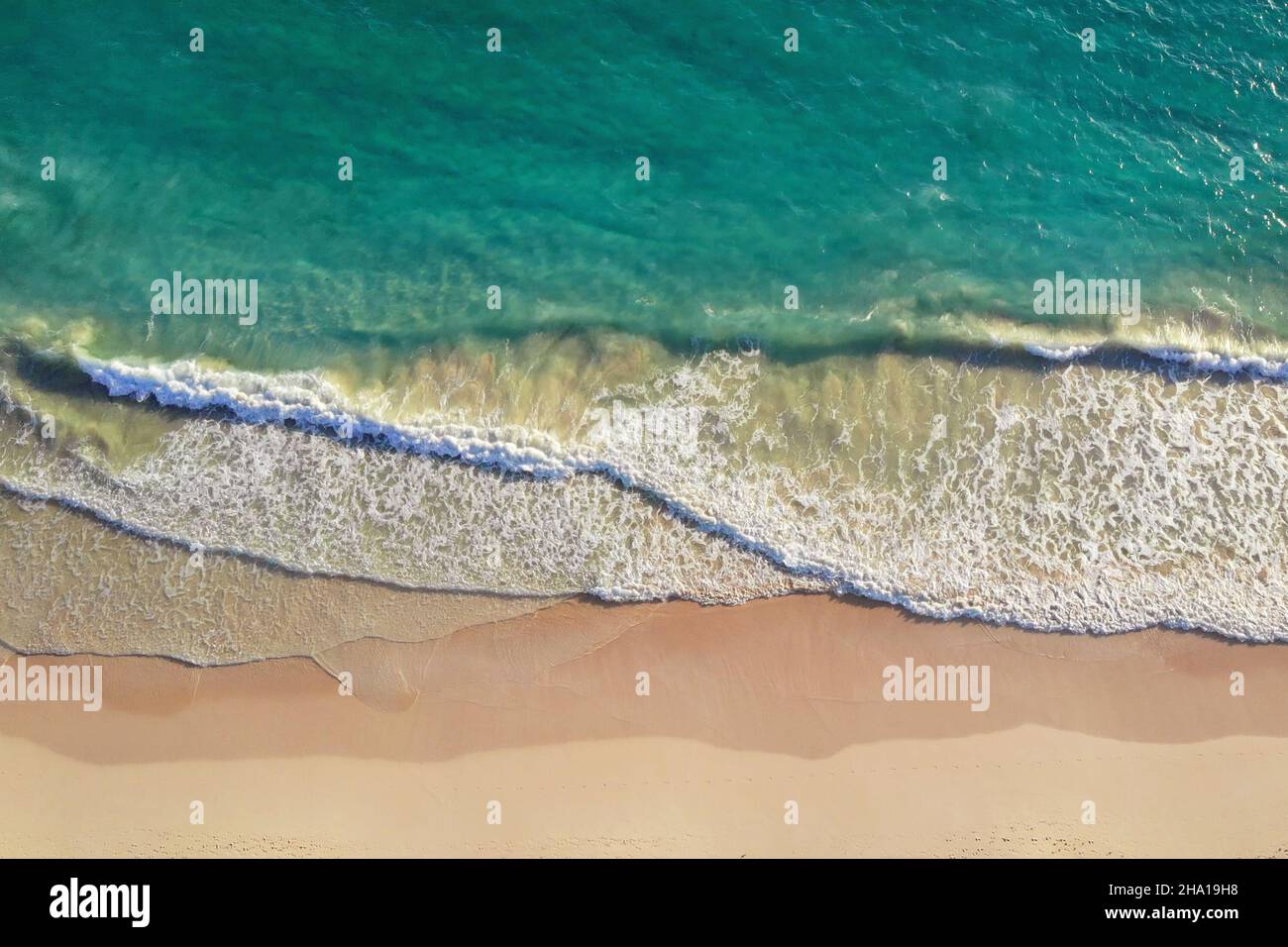 VISTA SUPERIOR. Relajante escena aérea en la playa, plantilla de vacaciones de verano. Olas surfear con increíble laguna azul del océano, costa del mar, costa. Perfecta vista aérea desde la cima del drone. Tranquila y luminosa playa, junto al mar Foto de stock