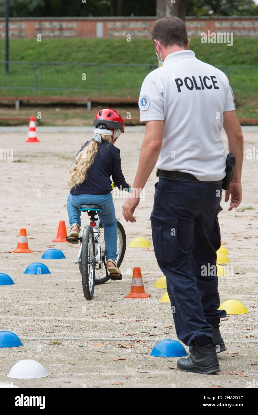 Actividad de seguridad vial: Niño en bicicleta y policía Foto de stock