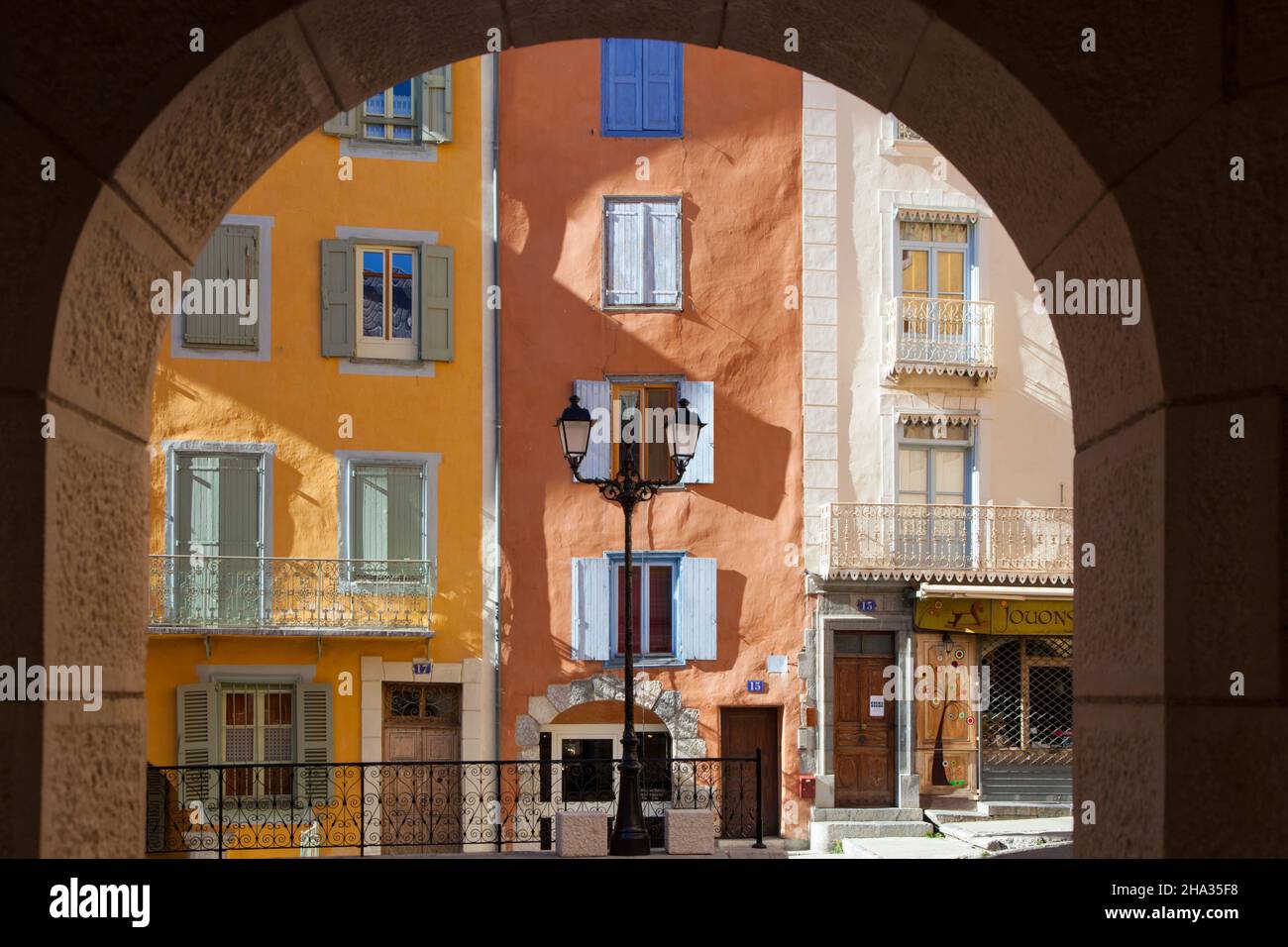 El casco antiguo de Briancon en Altos Alpes, ( Provence-Alpes-Côte d'Azur ) muestra casas de pueblo multicolores y antiguo poste a través de un arco Foto de stock