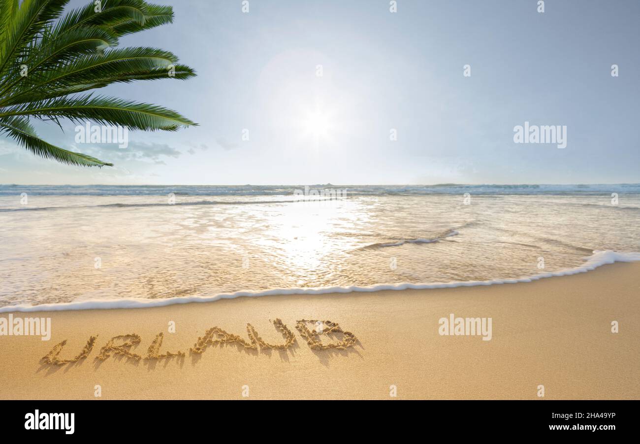la palabra vacaciones escritas en la arena en una playa de mar del sur Foto de stock