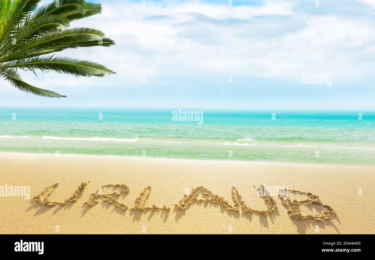 la palabra vacaciones escritas en la arena en una playa de mar del sur Foto de stock