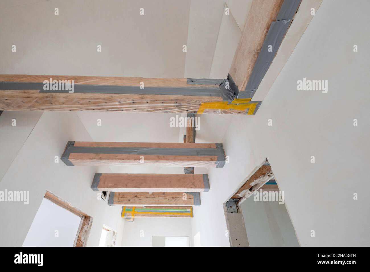 obra de construcción, renovación y renovación de un apartamento, techo con vigas de madera enmascarada Foto de stock