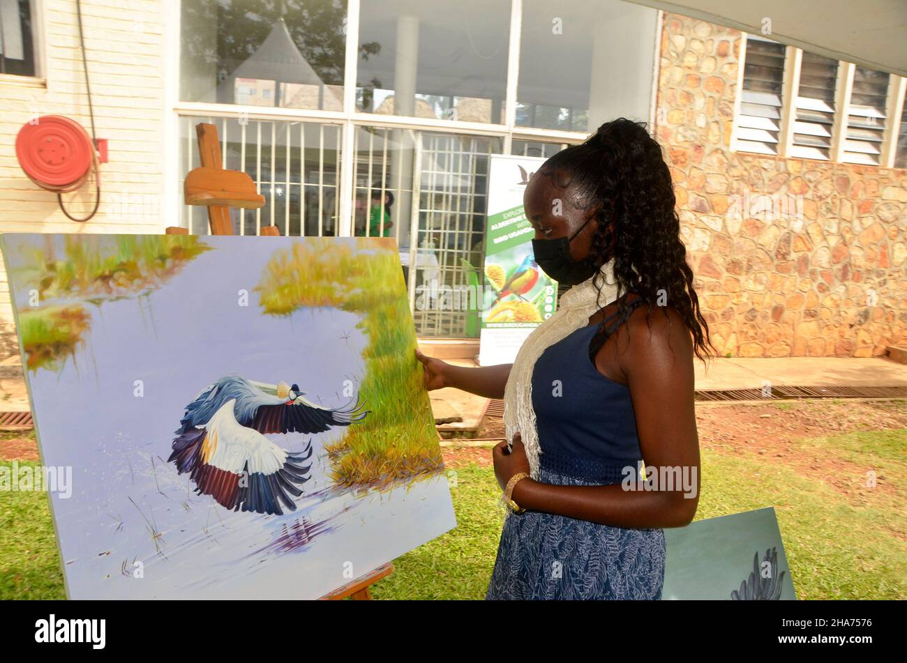 Kampala, Uganda. 10th de Dic de 2021. Un visitante observa la pintura de  una grúa coronada gris durante la Exposición Africana de Aves de 4th en  Kampala, Uganda, 10 de diciembre de