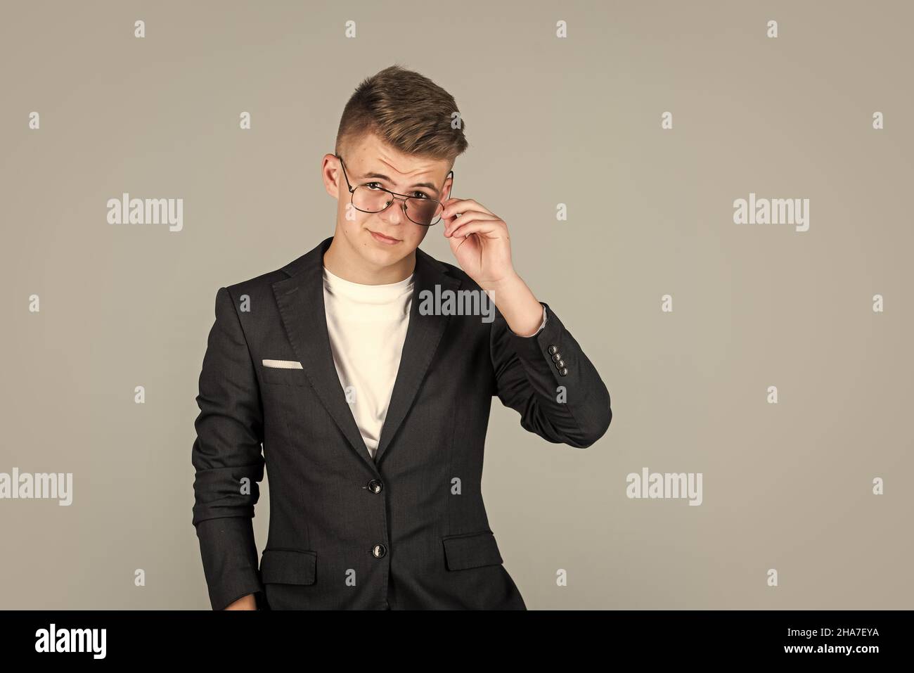 hombre de negocios de éxito. adolescente de moda. niño con chaqueta negra. niño seguro que lleva gafas. Foto de stock
