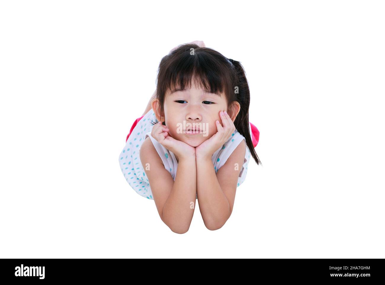 Una chica china se acuesta en el suelo y parece soñolenta. Niño asiático apuntalar la barbilla en el estudio. Aislado sobre fondo blanco. Conceptual sobre cansado, infeliz Foto de stock