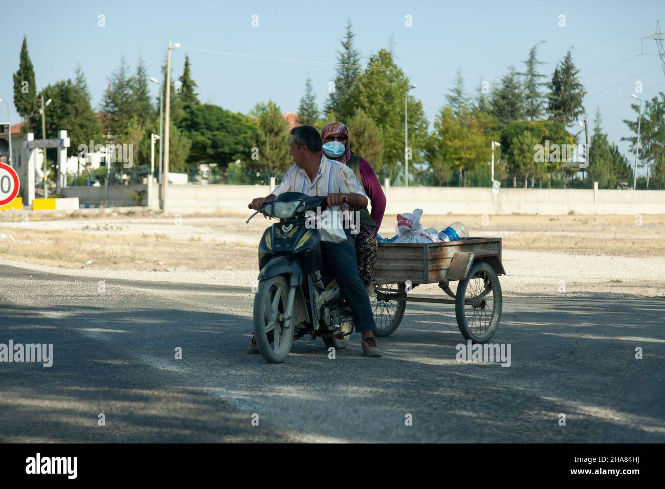 Antalya, Turquía - 08. 28. 2021: Pequeña motocicleta convertida en remolque de tres ruedas para transportar cargas ligeras. Foto de stock