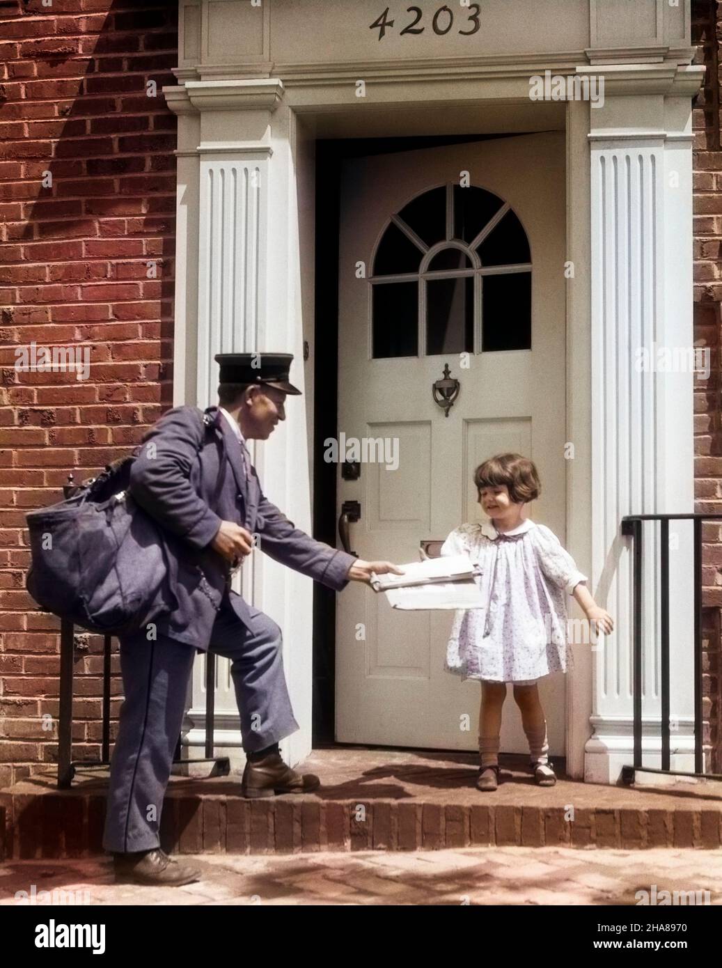 1920S NIÑA SONRIENTE RECIBIENDO CORREO DEL CARTERO AYT PUERTA DELANTERA DEL  EDIFICIO DE LADRILLO - J1373C HAR001 HARS ESTILO JUVENIL COMUNICACIÓN AMIGO ESTILO  DE VIDA MUJERES CASAS EMPLEO CASA VIDA GENTE NIÑOS