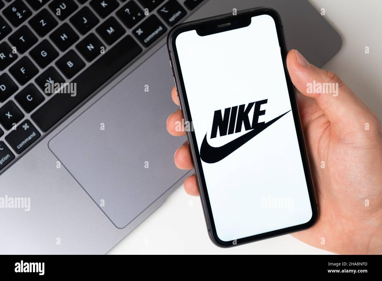 Logotipo de la aplicación Nike para realizar compras online en la pantalla del teléfono móvil. Hombre con la mano sosteniendo un smartphone con una aplicación. 2021 de noviembre, San EE.UU Fotografía