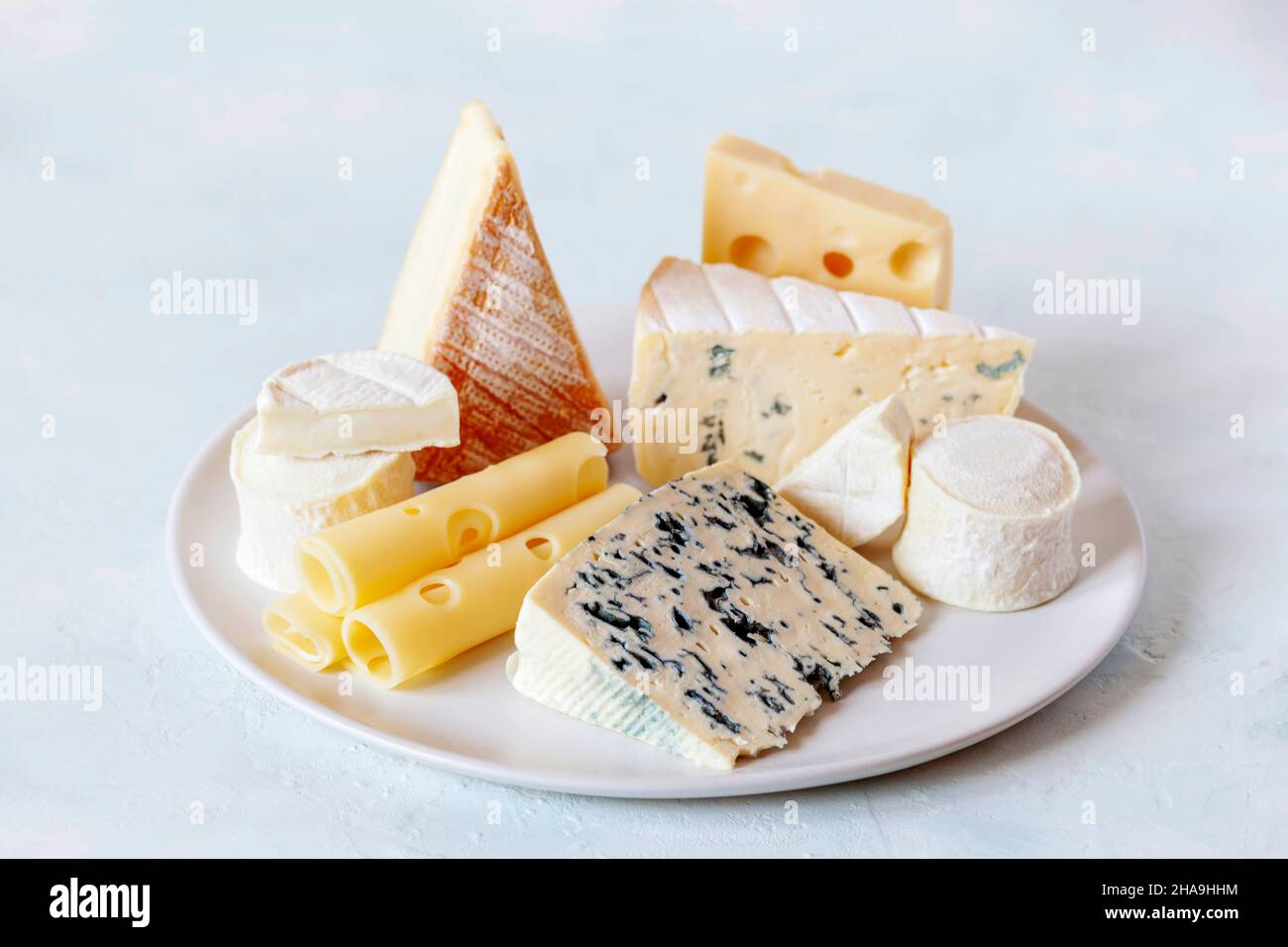 plato de queso con diferentes tipos de queso francés sobre fondo blanco Foto de stock