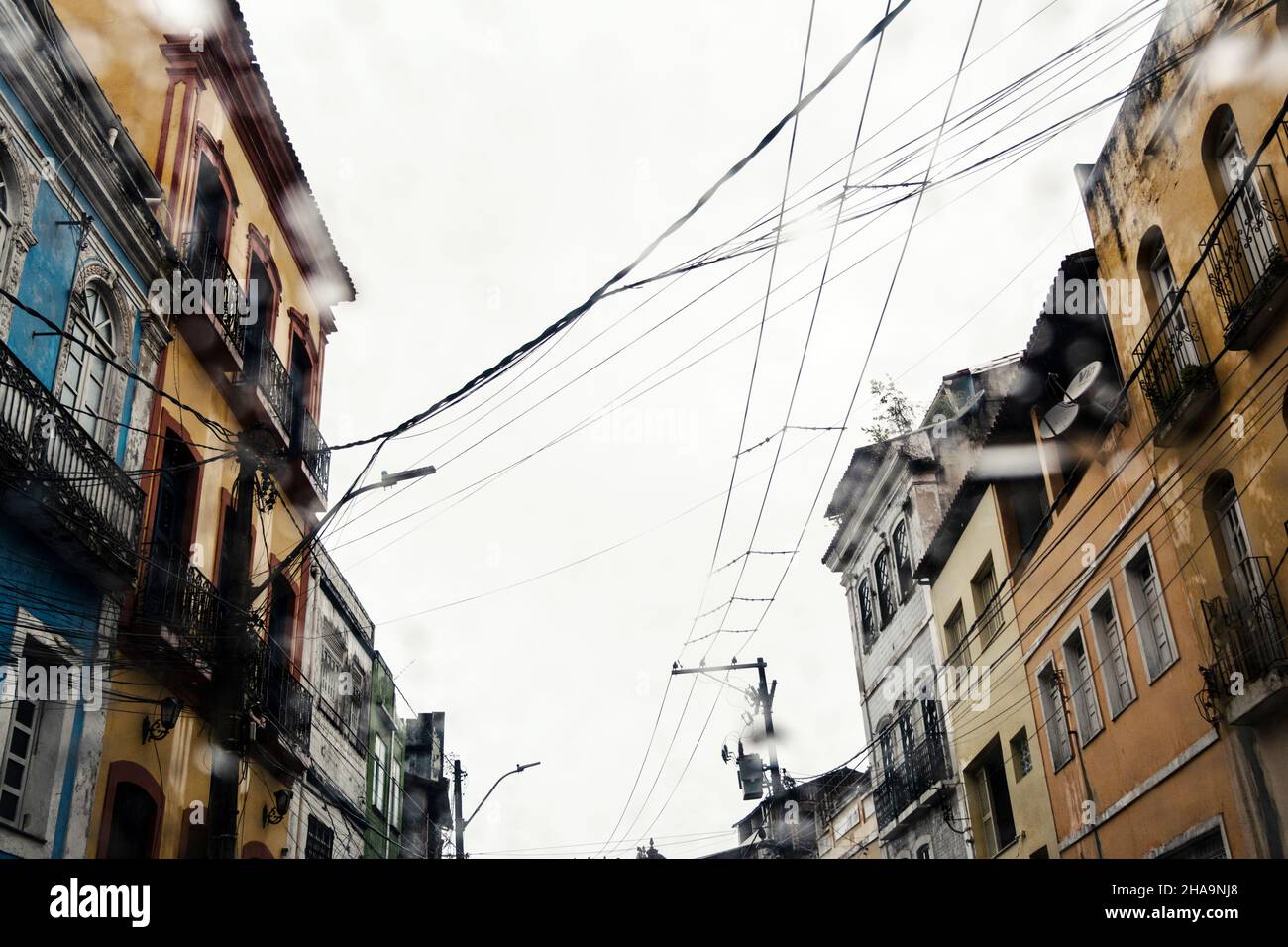 Cristal húmedo, coche dentro de la vista de la calle con edificios y casas. Salvador, Bahía, Brasil. Foto de stock