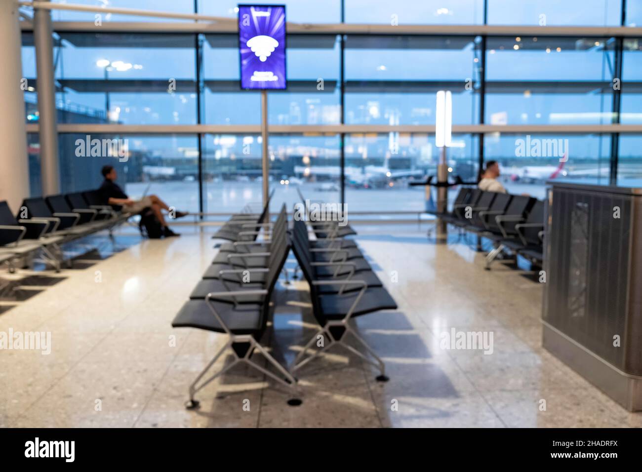Foto borrosa de una terminal del aeropuerto en las horas sin conexión con un anuncio wifi en una pantalla Foto de stock