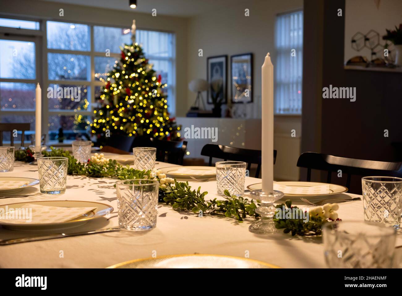 Una mesa fija para una fiesta de la cena de Navidad, con un árbol de Navidad en el fondo, Foto de stock
