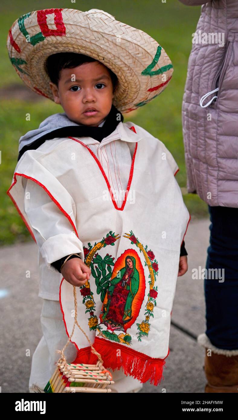 Un joven vestido con ropa mexicana tradicional observa la procesión durante  una fiesta de Guadalupe. Nuestra Señora de Guadalupe se celebra cada 12 de  diciembre porque se cree que Guadalupe se mostró