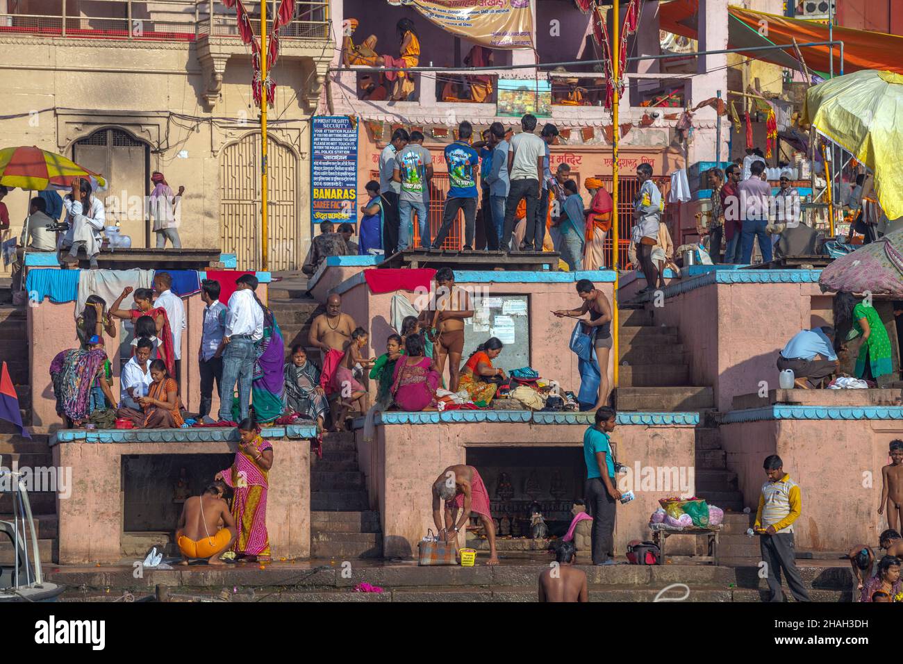 Peregrinos y sadhus en los santos ghats en Varanasi, India Foto de stock