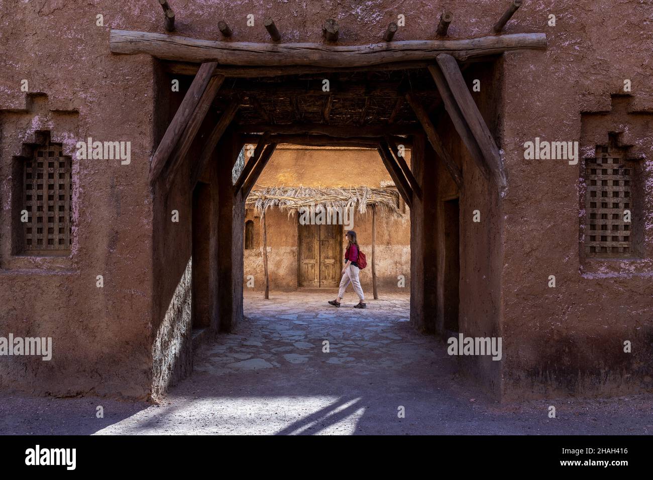 Una joven turista camina entre los antiguos edificios de barro de Ouarzazate en Marruecos Foto de stock