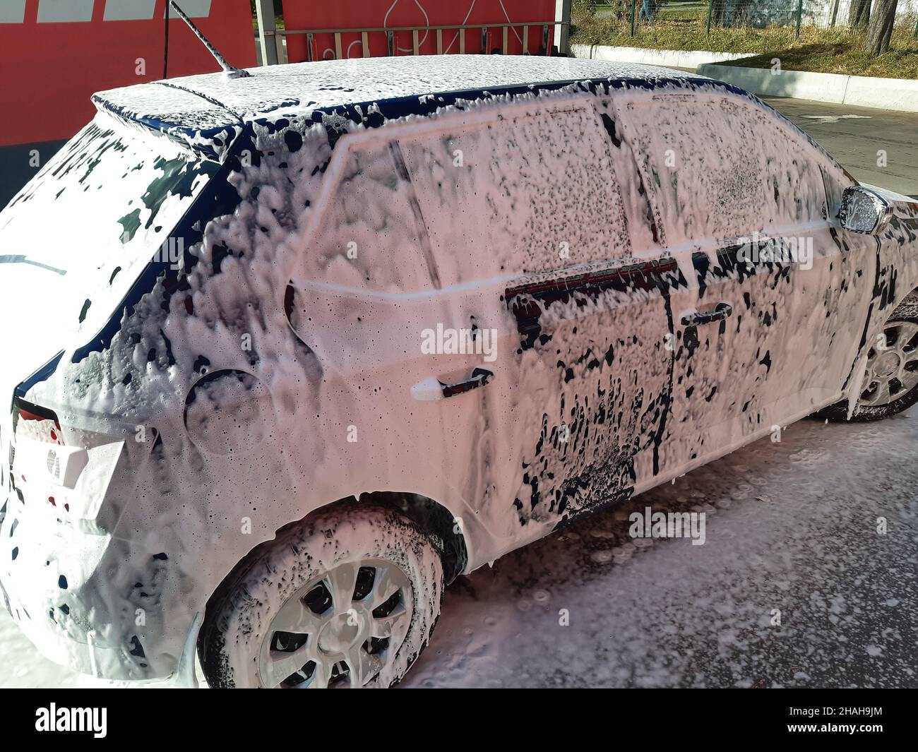 El hombre pone en el coche de espuma activa Mat. Lavado de coches. Complejo  de lavado de auto-servicio. Lavado de alta presión Fotografía de stock -  Alamy