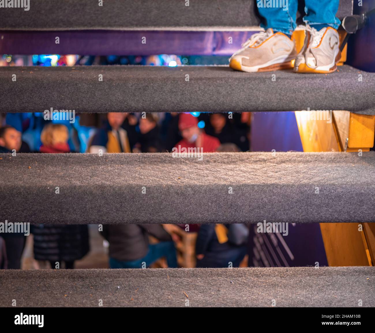 Una vista a través de las aberturas en las escaleras de un grupo de personas borrosas celebrando Foto de stock