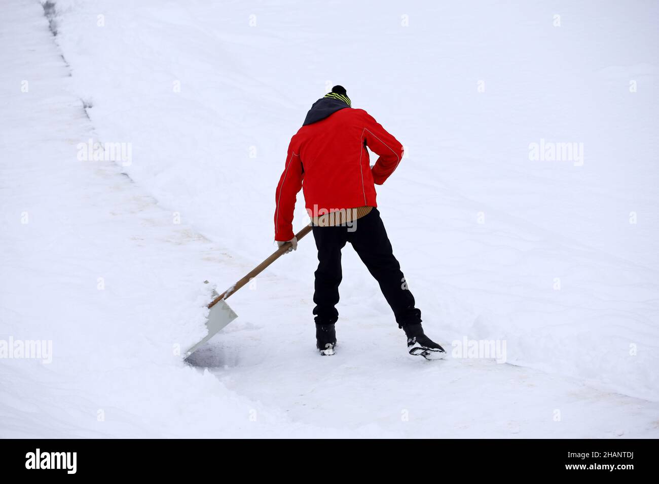 Hombre en ropa de invierno de limpieza con una pala de nieve en las  montañas Fotografía de stock - Alamy