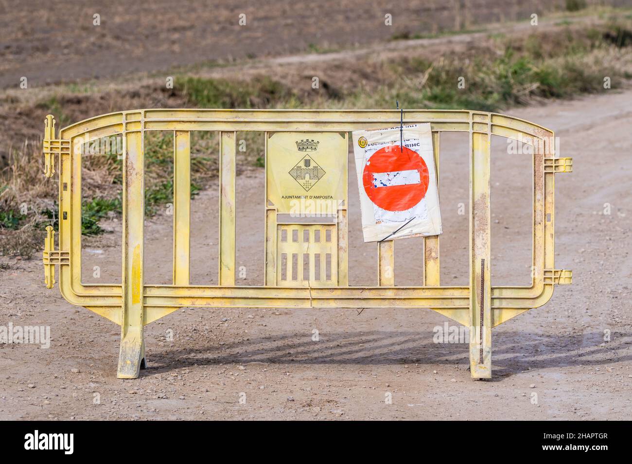 Señal de prohibición sobre barrera plástica, carretera de grava, Delta del Ebro, Cataluña, España Foto de stock