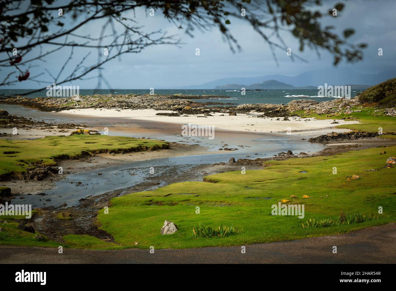 La ensenada y la playa de arenas blancas de Portuairk, el asentamiento más occidental de la tierra firme británica que tiene vistas de las pequeñas islas, Escocia occidental Foto de stock