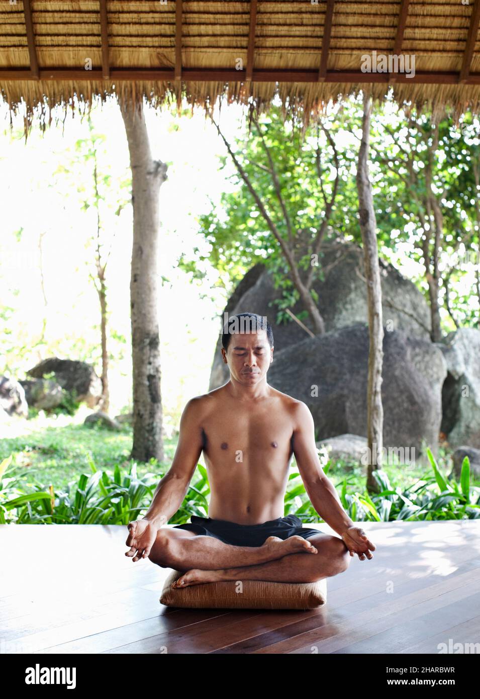 Hombre practicando Pranayama en Kamalaya, Koh Samui, Tailandia. El instructor de yoga Khun Chack practica pranayama o respiración yóguica. Foto de stock