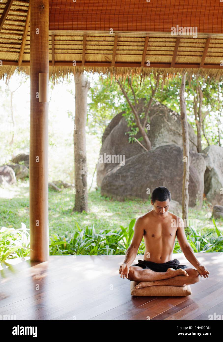 Hombre practicando Pranayama en Kamalaya, Koh Samui, Tailandia. El instructor de yoga Khun Chack practica pranayama o respiración yóguica. Foto de stock